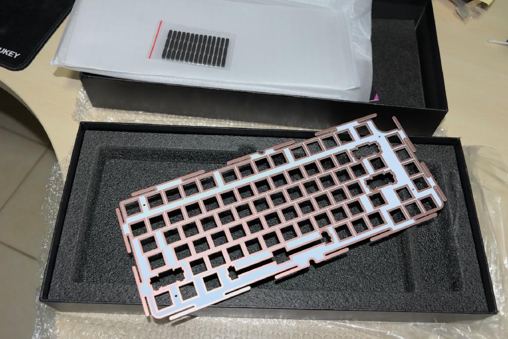La plaque en plastique, au cas où celle montée par défaut (en aluminium) serait trop rigide, ainsi que des _gaskets_ supplémentaires dans leur sachet refermable 719ya5