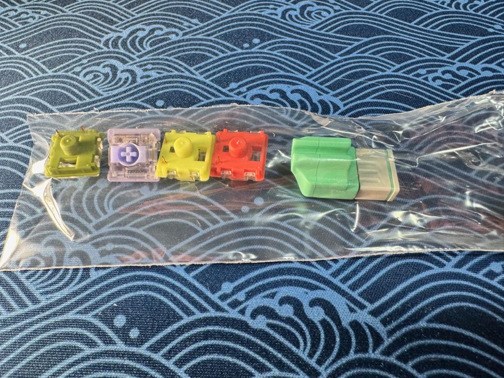 Quelques switches supplémentaires offerts pour tester les différents touchers offerts par la gamme. Bien vu ! Le dongle sans-fil est à droite, encapuchonné, et peut se clipser à un câble pour ne pas le perdre MzNTcK